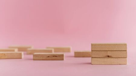 Wooden toys arranged on pink background for leisure activities conceptの写真素材