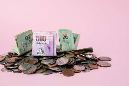 Thai currency banknote and money coins on pink background for business, finance, investment and saving money conceptの写真素材