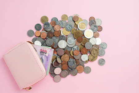 Wallet with Thai currency banknote and money coins on pink background for business, finance, investment and saving money conceptの写真素材