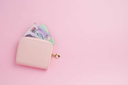 Wallet with Thai currency banknote on pink background for business, finance, investment and saving money conceptの写真素材