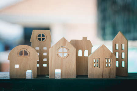 Wooden house model against blurred outdoor background for housing and property conceptの写真素材