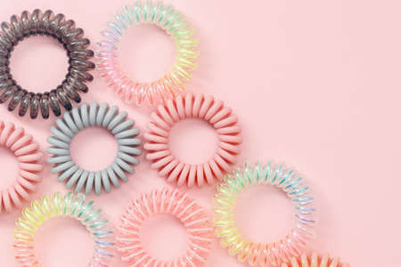 Spiral hair rubber bands on pink background for feminine accessories conceptの写真素材