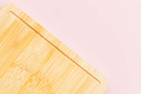 Wooden cutting board on pink background for kitchen utensil conceptの写真素材