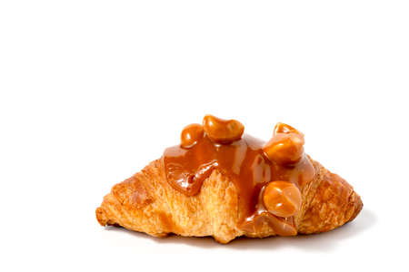 Croissant with caramel sauce and macadamia nut on white background for bakery, food and eating conceptの写真素材