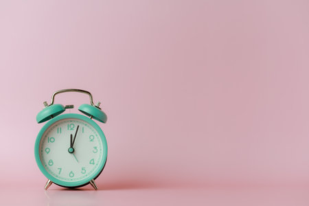 A bell alarm clock on pink background for the concept of time management.の写真素材