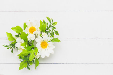 Top view of a fake bunch of flowers on white table background for nature decoration and springtime conceptの写真素材