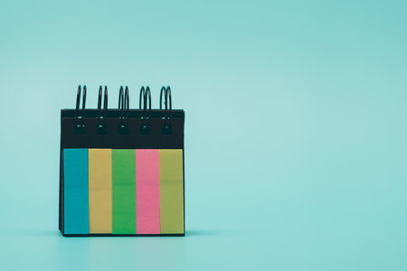 Colorful sticky notes arranged on blue background. Concept of reminders, planning, organization,...