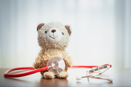 Teddy bear with stethoscope. Symbol of pediatric care, warmth, child healthcare, compassion, and emotional support in medical environments.の写真素材