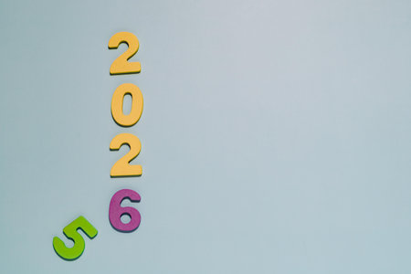 Artistically arranged vibrant 2026 on soft pastel blue. Perfect for themes of New Year anticipation,...