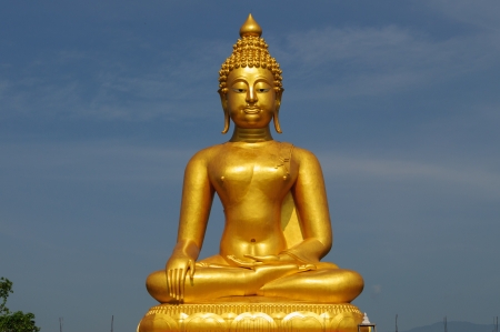 A golden buddha statue sits in peaceful meditationの写真素材