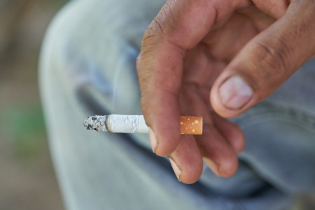 Close up man hand smoking cigarette.の写真素材