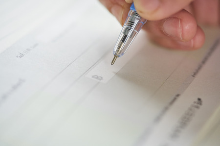 woman hand writing check, checque or cheque.の写真素材