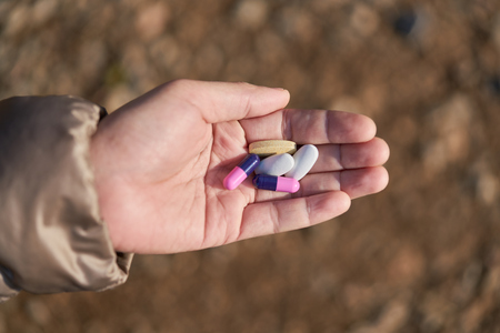Two-piece, hard starch medicine capsules and vitamin   in woman hand   .         の写真素材
