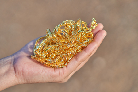 gold jewelry in lady hands.の写真素材
