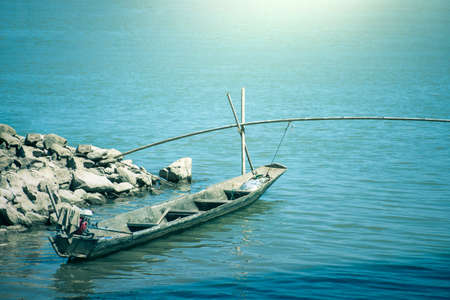 Small fishing boat and blue sea at sunrise.の写真素材