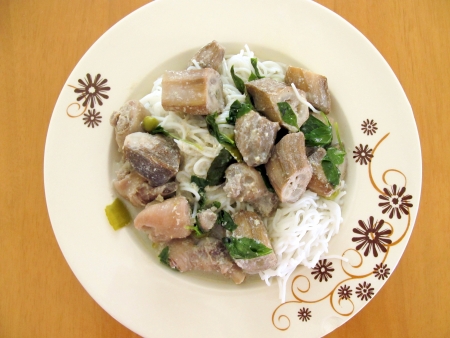 Thai green curry with raw banana and chicken eat with rice noodles on wood tableの写真素材