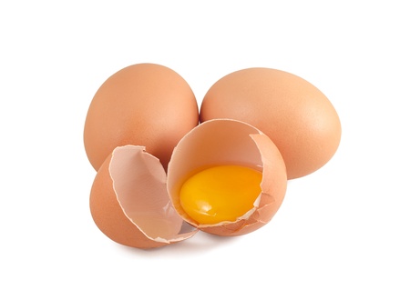 Three raw eggs one of them cracked isolated on white の写真素材