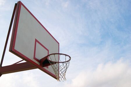 Basketball hoop with sky and clouds in uprisen angle view. Sport time