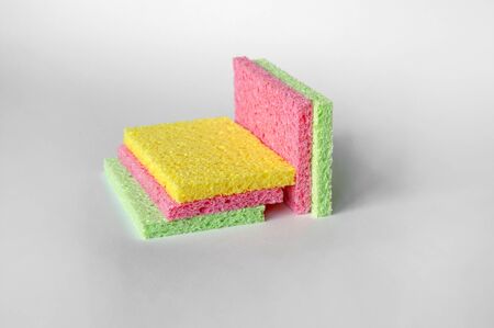 Bright colored sponges for washing dishes, cleaning the bathroom and other household needs are located one above the other. Isolated. Close-upの写真素材