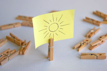 Yellow sticker on a small pin with a painted sun.