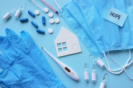 A three-layer medical mask with rubber ear straps, a syringe, a thermometer and various medicines,...