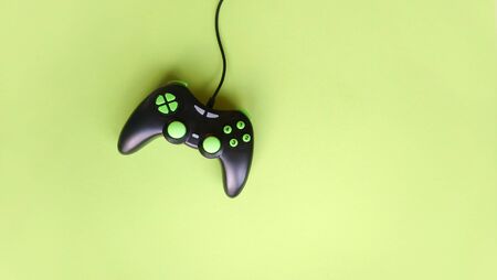Joystick gaming controller isolated on green background. Minimalism. Game concept.