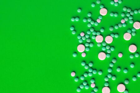 Assorted pharmaceutical medicine pills, tablets. Heap of assorted various medicine tablets and pills different colors on green background. Health care.Top view. Copy spaceの写真素材