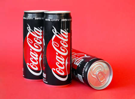 KHARKOV, UKRAINE - DECEMBER 23, 2019: Close-up of Coca Cola jars on red paper background.のeditorial素材