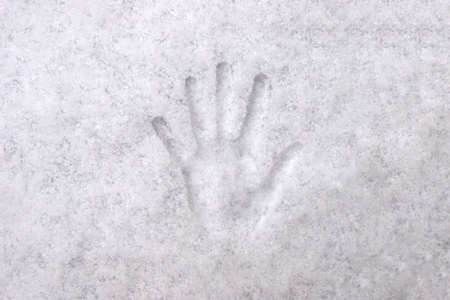 Handprint with fingers in white snow, background, texture.