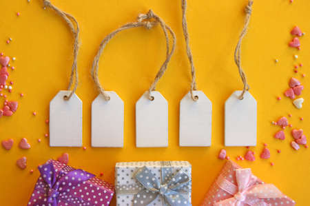 Five wooden tags with space for text on a yellow background.の写真素材