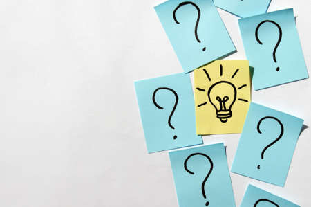 Stickers with question marks and a single light bulb as a sign of a good idea. Concept of business,...