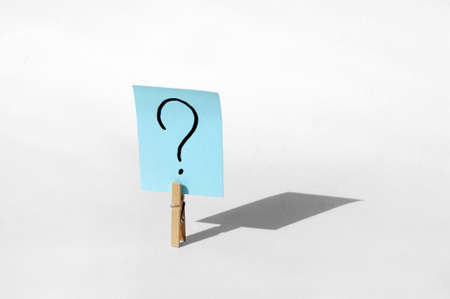 One clothespin with a question mark on the sticker with a big shadow. The concept of business,...