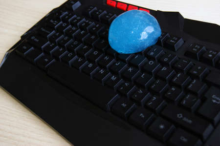 Blue soft gel cleaning dust on keyboard. Concept cleaning your computer's keyboard.