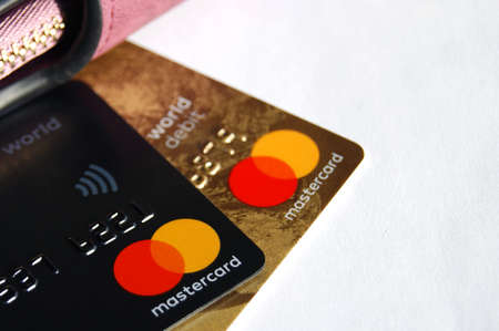 KHARKOV, UKRAINE - FEBRUARY 8, 2020: Close up of a Master Card Credit Card on white background. Nearby is a women's walletのeditorial素材