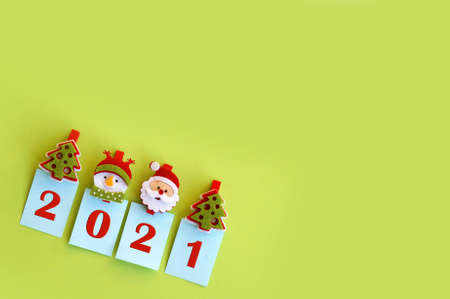 Photo greeting card happy new year 2021. Year 2021 on a green background and symbols of the winter holiday.の写真素材