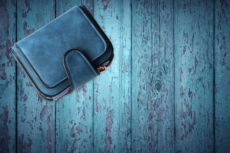 Blue women wallet isolated on blue wood background. View from above.の写真素材