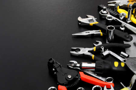 Many different tools for repair work on a black background with copy space for text. Repair and...