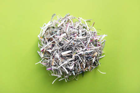 Shredded paper on light green background. Selective focus image.