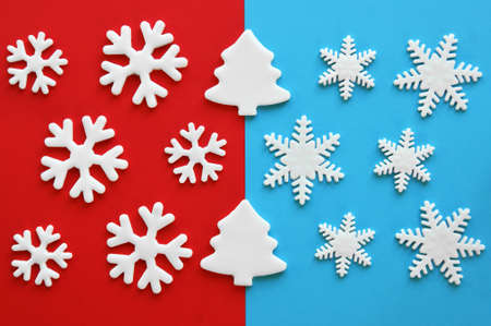 White carved christmas trees and snowflakes of mastic on red and blue background. Winter holiday....