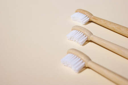 Three natural bamboo toothbrushes on light background.の写真素材