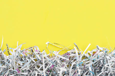 The shredded paper on light yellow background.の写真素材