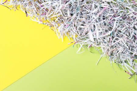 The shredded paper on light yellow and green background.の写真素材