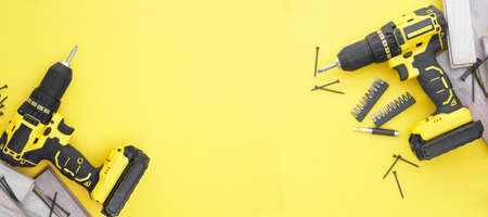 Yellow-black screwdriver on a yellow background, screws, a set of bits. Copy space.の写真素材