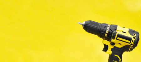The yellow-black screwdriver on a yellow background.の写真素材