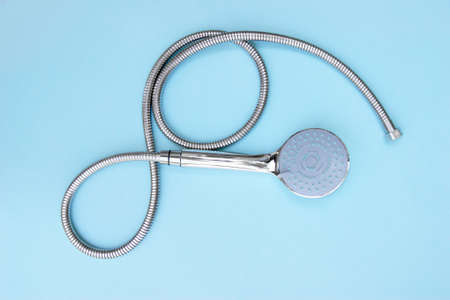 The shower head chrome coated multi-mode for the bathroom with hose on blue background. Top view