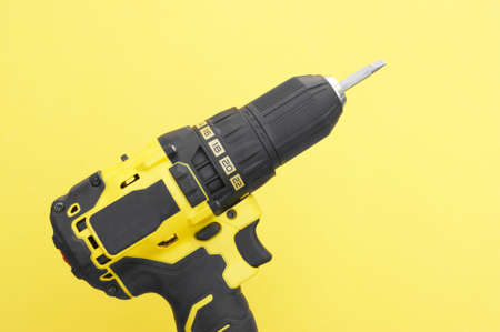Yellow-black screwdriver on a yellow background.