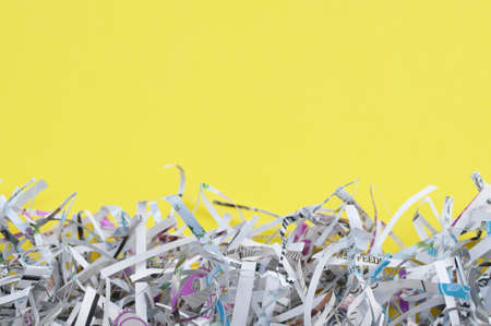 Shredded paper on light yellow background. Selective focus image.