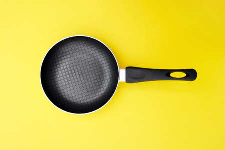 A non-stick skillet on a bright yellow background. Cooking concept.の写真素材