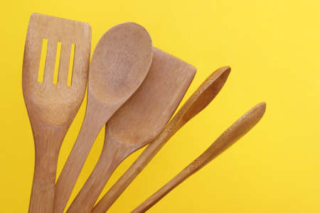 A set of bamboo dishes on a bright yellow background.
