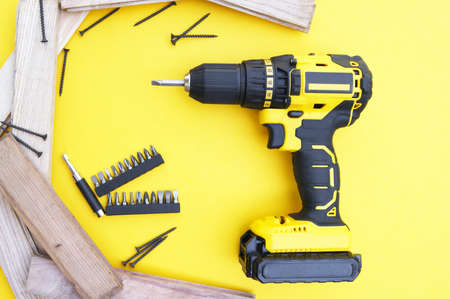 Yellow-black screwdriver on a yellow background, screws, a set of bits. Copy space.の写真素材
